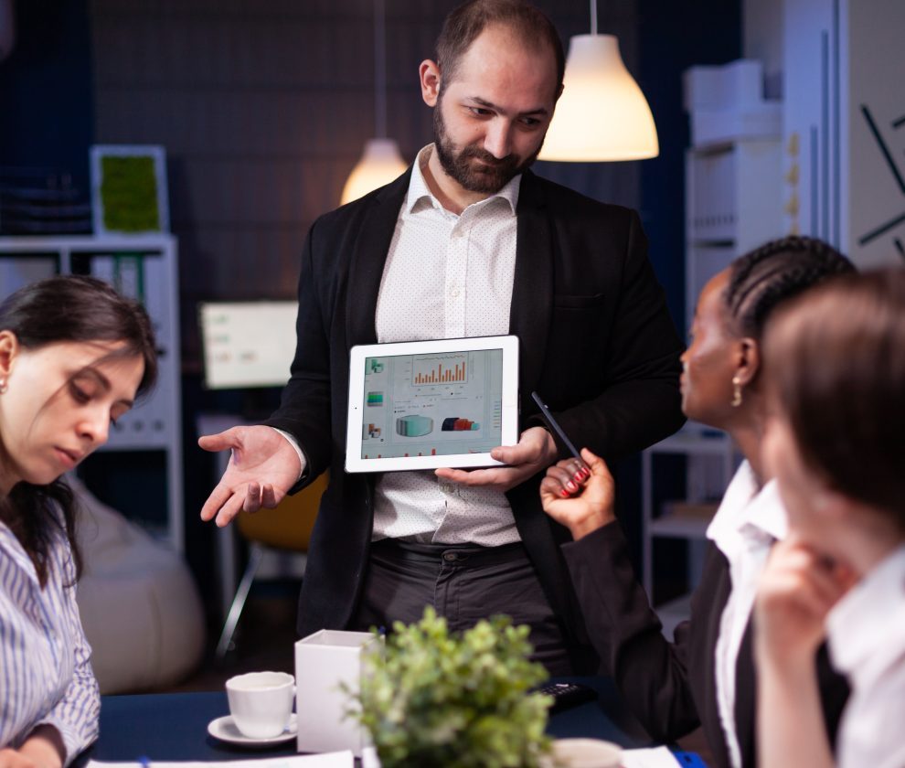 Focused workaholic entrepreneur man working overtime presenting company statistics